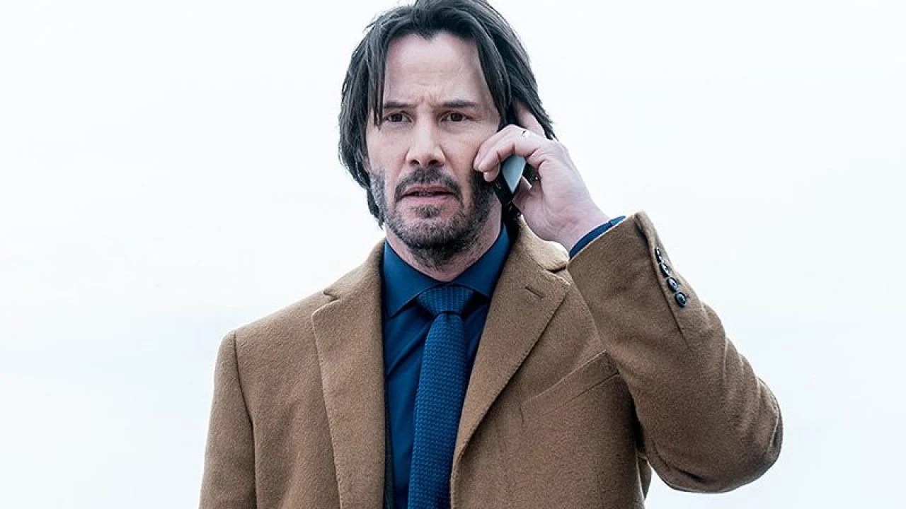 Keanu on mobile phone looking unhappy