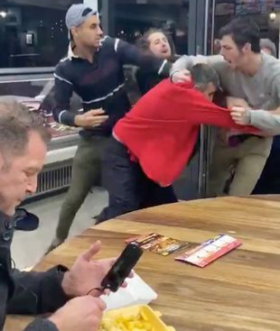 Man ignoring fight while on phone